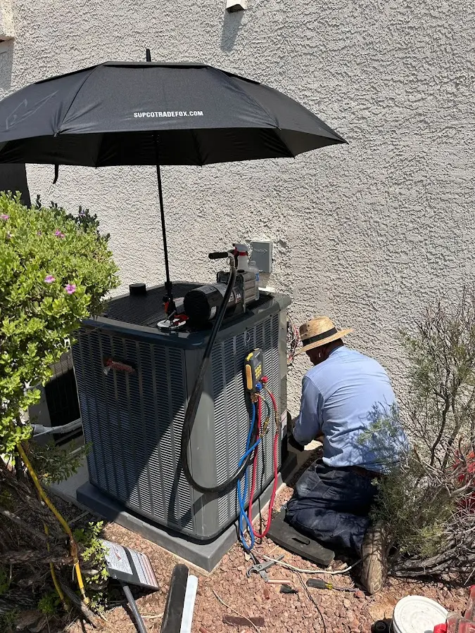 HVAC technician performing outdoor AC maintenance in Ellicott