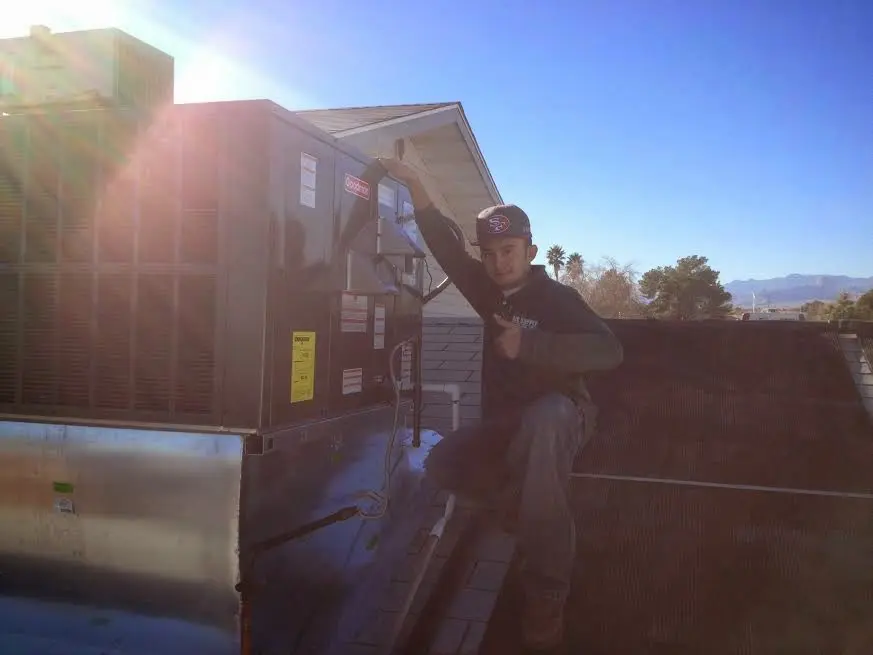 HVAC technician performing Boiler Repair on a rooftop unit in Ellicott
